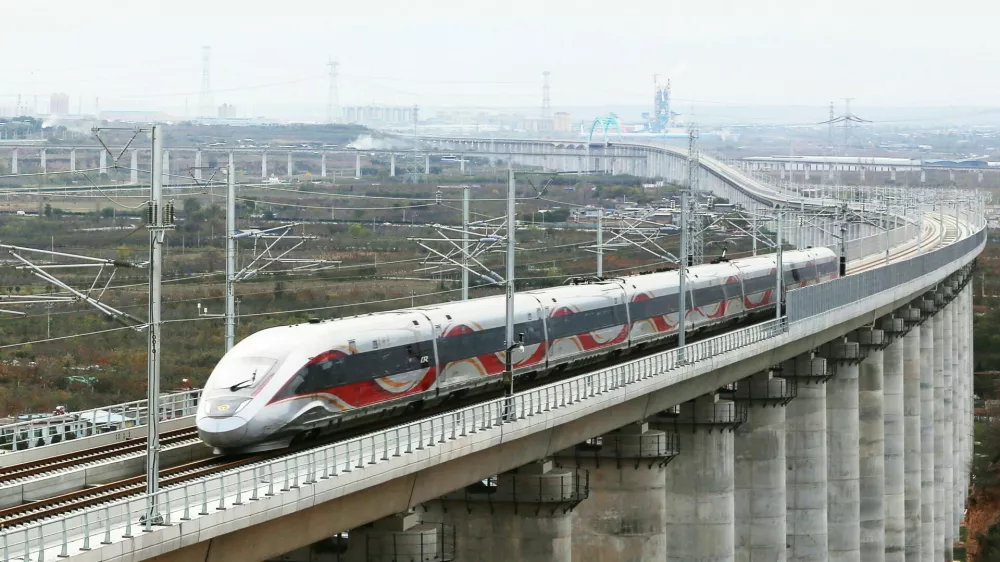 XI'AN, Nov. 17, 2025 -- A drone photo taken on Nov. 17, 2025 shows a test train running on a grand bridge of a high-speed railway line connecting Xi'an with Yan'an in northwest China's Shaanxi Province. A high-speed railway line connecting Xi'an, the capital of northwest China's Shaanxi Province, with Yan'an in northern Shaanxi has entered its trial operation phase, marking a significant step toward full operation. The trial run commenced on Monday morning when test train 55302 departed from Xi'an toward Yan'an -- transitioning from the joint debugging and testing phase to operational simulations. As the first high-speed railway in northern Shaanxi's old revolutionary base area, this 299.8-km project is designed for speeds of 350 km per hour and slashes the journey duration between Xi'an and Yan'an from 2.5 hours to approximately one hour. Yan'an holds profound historical significance -- as it served as the base of the Communist Party of China leadership between 1937 and 1947.,Image: 1052947556, License: Rights-managed, Restrictions:, Model Release: no
