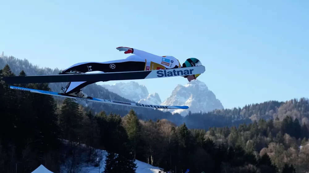 Domen Prevc, of Slovenia, soars through the air, with the Zugspitze and Waxenstein mountains in the background, during his trial jump at the second stage of the Four Hills ski jumping tournament in Garmisch-Partenkirchen, Germany, Wednesday, Dec. 31, 2025. (AP Photo/Matthias Schrader)