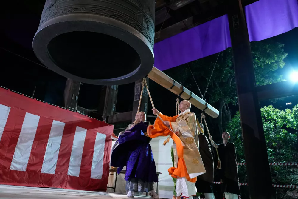 Monks strike a giant bell to celebrate the New Year at the Zojoji Buddhist temple, minutes after midnight Thursday Jan. 1, 2026, in Tokyo. (AP Photo/Eugene Hoshiko)