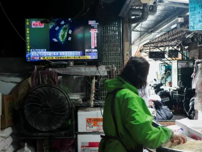 A woman works in a noodle store near a television screen showing a news report on China's "Justice Mission 2025" military drills around Taiwan, in Taipei, Taiwan, December 29, 2025. REUTERS/Tsai Hsin-Han