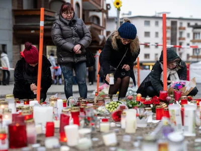 People light candles near the sealed off Le Constellation bar, where a devastating fire left dead and injured during the New Year's celebrations in Crans-Montana, Swiss Alps, Switzerland, Friday, Jan. 2, 2026. (Alessandro della Valle/Keystone via AP)