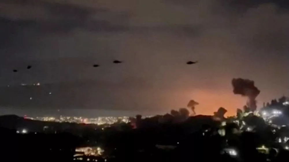 Helicopters fly past plumes of smoke rising from explosions, in Caracas, Venezuela, January 3, 2026 in this screen grab obtained from video obtained by Reuters. Video Obtained by Reuters/via REUTERS THIS IMAGE HAS BEEN SUPPLIED BY A THIRD PARTY. NO RESALES. NO ARCHIVES. NEWS USE ONLY. THIS PICTURE WAS PROCESSED BY REUTERS TO ENHANCE QUALITY. AN UNPROCESSED VERSION HAS BEEN PROVIDED SEPARATELY. VERIFICATION: - Mountains, towers and buildings match satellite and file imagery of Caracas - Date verified by multiple corroborating videos of strikes on Caracas   TPX IMAGES OF THE DAY
