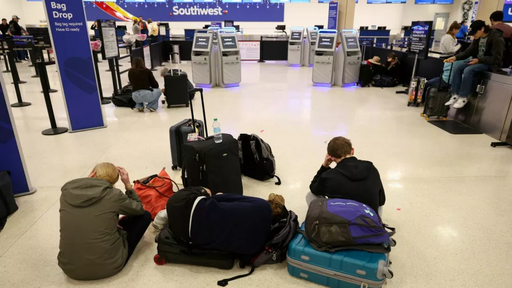 Passengers rest on the floor, after flights were delayed and cancelled when the airspace was closed due to U.S. strikes on Venezuela overnight, at Luis Munoz Marin International Airport in Carolina, near San Juan, Puerto Rico January 3, 2026. REUTERS/Ricardo Arduengo