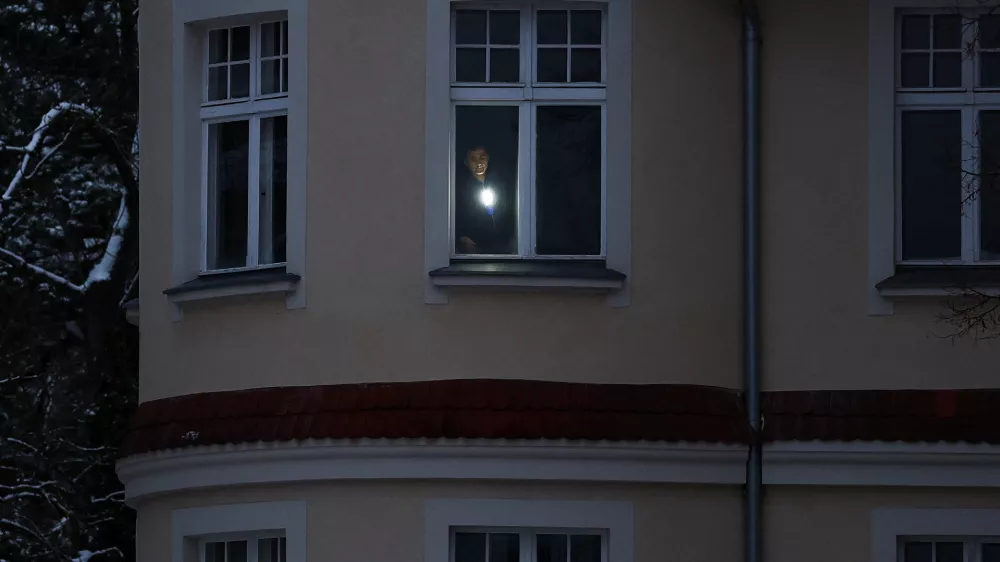 A man uses a torch in his apartment during a blackout that left thousands of homes without electricity after a suspected arson attack at the power plant Lichterfelde, in the district Steglitz-Zehlendorf, in southern Berlin, Germany, January 4, 2026. REUTERS/Lisi Niesner