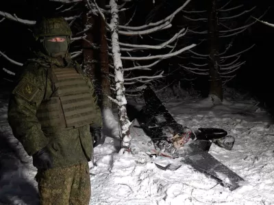 This image made from undated video provided by the Russian Defense Ministry Press Service on Wednesday, Dec. 31, 2025, shows a man in camouflage standing by a downed drone at an undisclosed location that it said was one of the Ukrainian drones involved in an alleged attack on a residence of President Vladimir Putin this week &ndash; a claim Kyiv has denied as a "lie". (Russian Defense Ministry Press Service via AP)