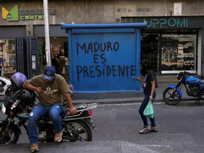 People walk in front of graffiti that reads "Maduro is president", days after the U.S. launched a strike on Venezuela and captured President Nicolas Maduro and his wife Cilia Flores, in Caracas, Venezuela, January 6, 2026. REUTERS/Gaby Oraa / Foto: Gaby Oraa