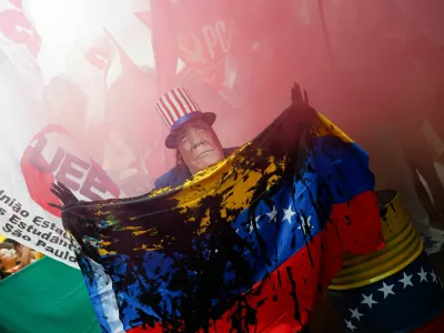 A man wears a mask depicting U.S. President Donald Trump during a protest against U.S. strikes on Venezuela and the capture of its President Nicolas Maduro, in Sao Paulo, Brazil January 5, 2026. REUTERS/Tuane Fernandes