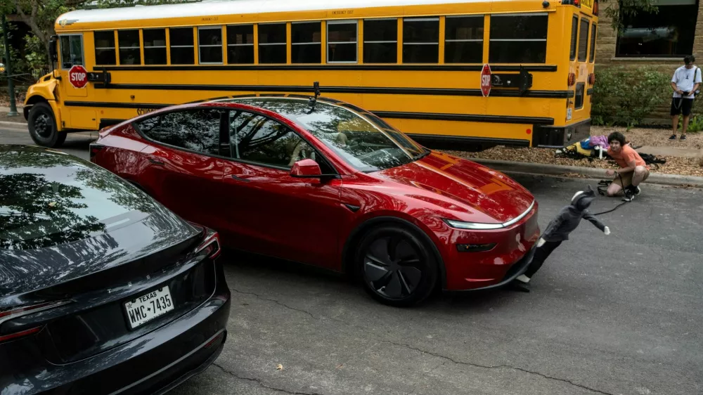 FILE PHOTO: Arthur Maltin, a test driver with The Dawn Project, hits a crash dummy as it crosses the road during a safety test on a Tesla Model Y's self-driving feature at a protest against Tesla robotaxis, ahead of the Tesla robotaxis' official services in Austin, Texas, U.S., June 12, 2025.  REUTERS/Joel Angel Juarez/File Photo