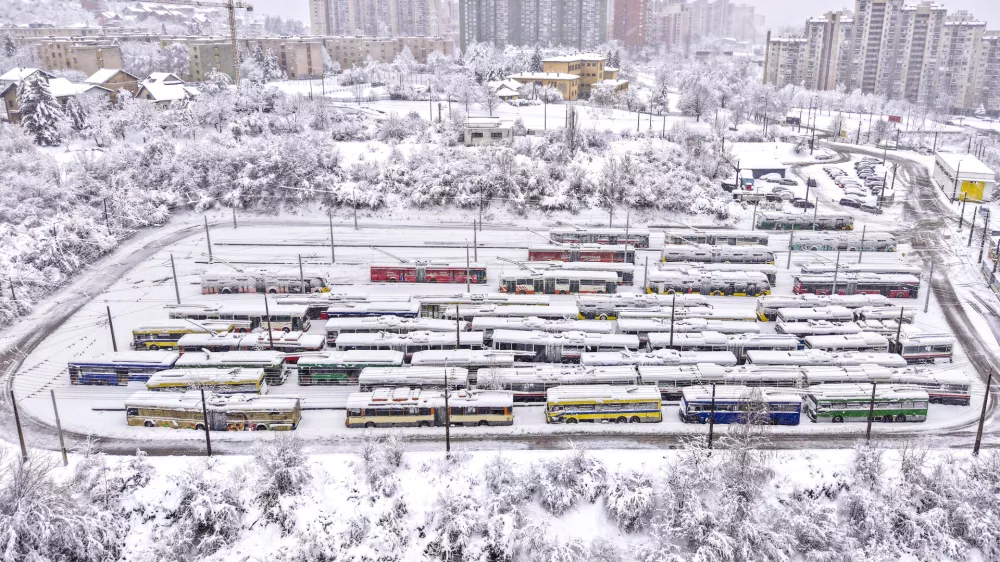 An aerial view of parked trolley buses during heavy snowfall in Sarajevo, Bosnia, Tuesday, Dec. 24, 2024. (AP Photo/Armin Durgut)