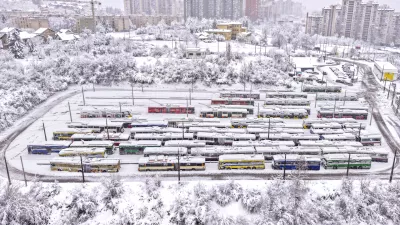 An aerial view of parked trolley buses during heavy snowfall in Sarajevo, Bosnia, Tuesday, Dec. 24, 2024. (AP Photo/Armin Durgut)