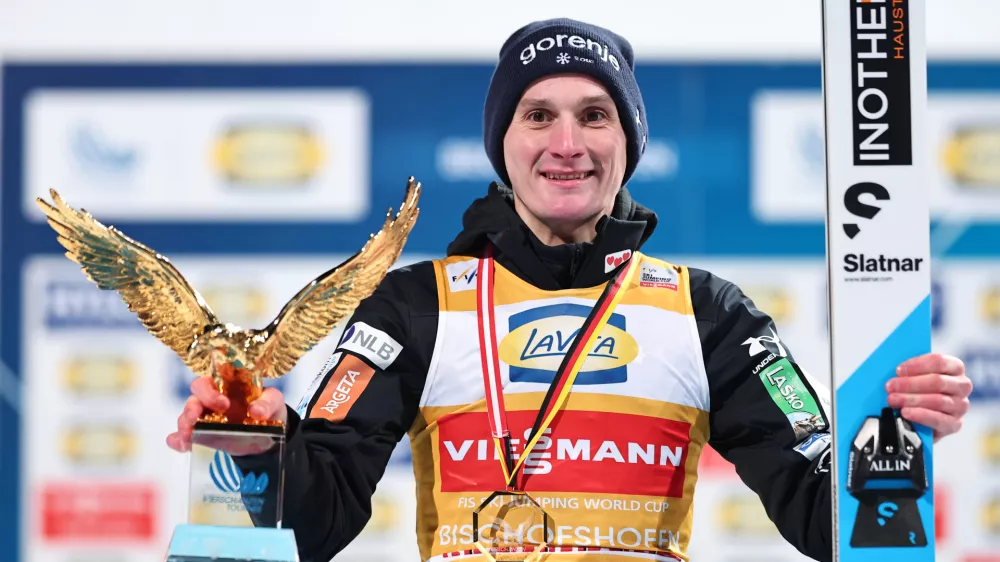 06 January 2026, Austria, Bischofshofen: Slovenia's Domen Prevc celebrates on the podium with his trophy during the men's Four Hills Tournament large hill 1st round of the Nordic skiing/ski jumping World Cup. Photo: Daniel Karmann/dpa