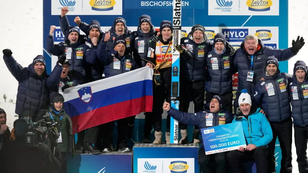Domen Prevc, of Slovenia, center, poses with his team after winning the Four Hills ski jumping tournament in Bischofshofen, Austria, Tuesday, Jan. 6, 2026. (AP Photo/Matthias Schrader)