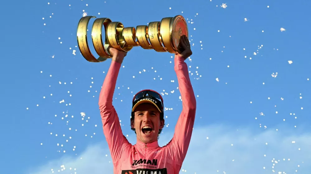 Cycling - Giro d'Italia - Stage 21 - Rome to Rome - Italy - June 1, 2025 Team Visma | Lease a Bike's Simon Yates celebrates with a trophy on the podium after winning the Giro d'Italia REUTERS/Jennifer Lorenzini  TPX IMAGES OF THE DAY