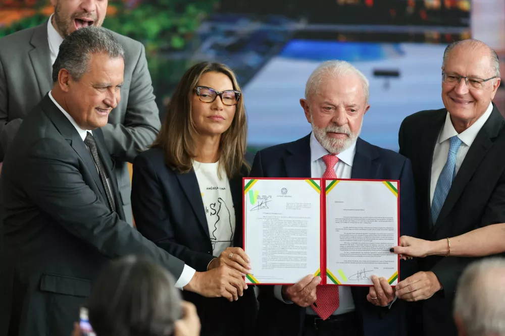 Brazil's President Luiz Inacio Lula da Silva, his wife Rosangela "Janja" da Silva and Vice President Geraldo Alckmin hold a signed veto to a bill cutting former President Jair Bolsonaro's 27-year prison sentence, during a ceremony to mark the third anniversary of Bolsonaro's failed coup attempt, in Brasilia, Brazil, January 8, 2026. REUTERS/Jorge Silva