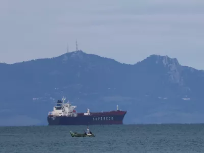 A Moroccan fisherman sails next to an oil tanker crossing the Strait of Gibraltar with the Atlas Mountains in the background, near the Spanish town of Tarifa, as seen from Tangier, Morocco, January 8, 2026. REUTERS/Amr Abdallah Dalsh
