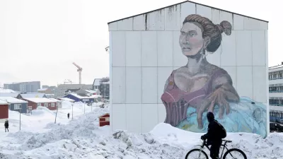 FILE PHOTO: A man passes a building with social housing with an Inuit mural in Nuuk, Greenland, March 27, 2025. REUTERS/Leonhard Foeger/File Photo / Foto: Leonhard Foeger