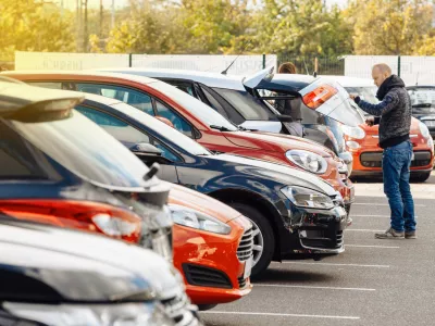 Paris, France - October 10, 2015: View from the street of man choosing new car - looking at the big trunk - new car to choose the most precious one