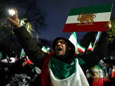 A man gestures while displaying the "Lion and Sun" pre-Iranian Revolution national flag as demonstrators gather outside the Iranian embassy during a rally in support of nationwide protests in Iran, in London, Britain, January 11, 2026. REUTERS/Isabel Infantes