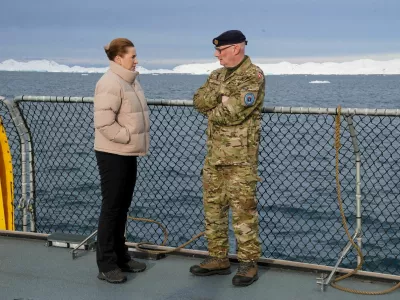FILE PHOTO: Denmark's Prime Minister Mette Frederiksen talks with the head of the Arctic Command Soeren Andersen, aboard the Defense's inspection vessel Vaedderen in the waters around Nuuk, Greenland, April 3, 2025. REUTERS/Tom Little/File Photo