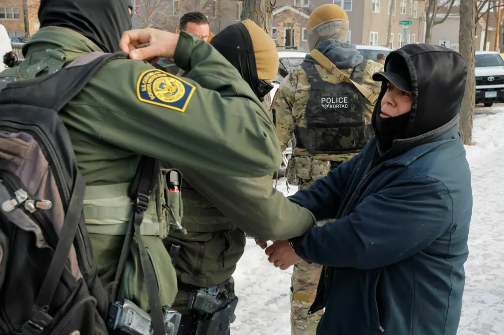 U.S. Customs and Border Patrol agents handcuff and detain a man off the sidewalk who could not prove his immigration status, after a U.S. Immigration and Customs Enforcement (ICE) agent fatally shot Renee Nicole Good, in Minneapolis, Minnesota, U.S., January 11, 2026.  REUTERS/Brian Snyder