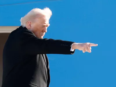 President Donald Trump gestures from the stairs of Air Force One as he boards upon his arrival at Joint Base Andrews, Md., Tuesday, Jan. 13, 2026. (AP Photo/Luis M. Alvarez)