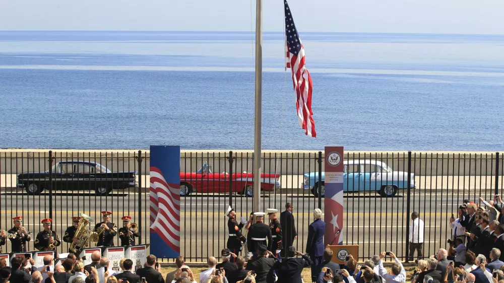 U.S. marines raise the U.S. flag while watched over by U.S. Secretary of State John Kerry (C, at lectern, back to camera) at the U.S. embassy in Havana, Cuba, August 14, 2015. U.S. Marines raised the American flag at the embassy in Cuba for the first time in 54 years on Friday, symbolically ushering in an era of renewed diplomatic relations between the two Cold War-era foes. REUTERS/Stringer    TPX IMAGES OF THE DAY