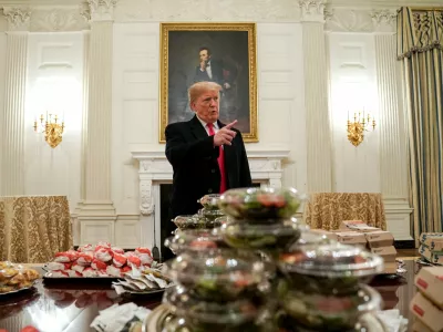U.S. President Donald Trump speaks in front of fast food provided for the 2018 College Football Playoff National Champion Clemson Tigers due to the partial government shutdown in the State Dining Room of the White House in Washington, U.S., January 14, 2019.   REUTERS/Joshua Roberts   TPX IMAGES OF THE DAY