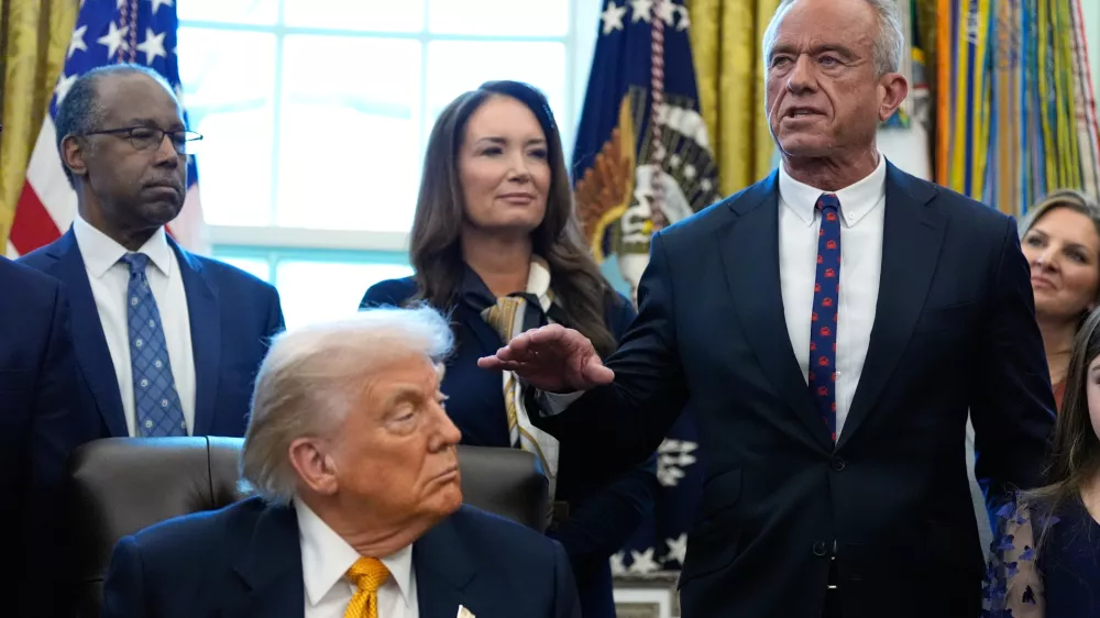 President Donald Trump, Dr. Ben Carson, Agriculture Secretary Brooke Rollins listen as Health and Human Services Secretary Robert F. Kennedy Jr. speaks in the Oval Office of the White House, Wednesday, Jan. 14, 2026, in Washington. (AP Photo/Alex Brandon)