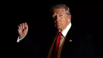 FILE - President Donald Trump is illuminated by a camera flash as he gestures while walking across the South Lawn of the White House, Nov. 2, 2025, in Washington, after returning from a trip to Florida. (AP Photo/Mark Schiefelbein, File)
