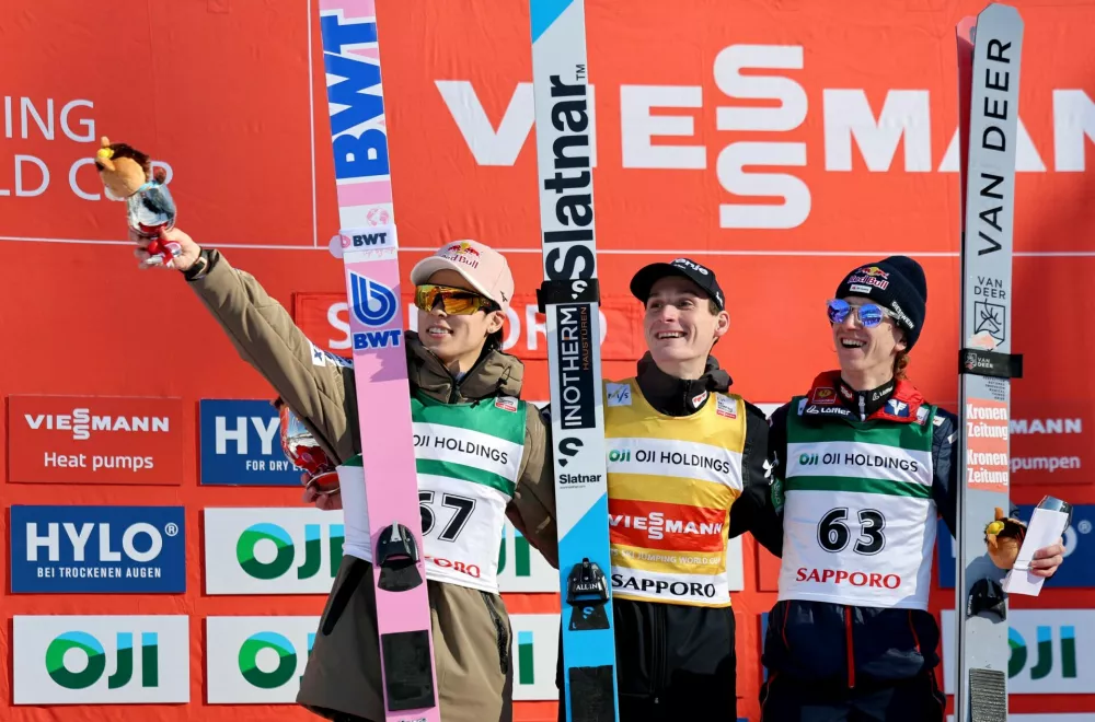 Ski Jumping - Ski Jumping World Cup - Sapporo, Japan - January 18, 2026 First placed Slovenia's Domen Prevc celebrates on the podium after winning men's individual HS137 alongside second placed Japan's Ryoyu Kobayashi and third placed Austria's Daniel Tschofenig REUTERS/Issei Kato