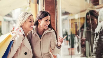 Women in shopping. Two happy women with shopping bags enjoying in shopping, having fun in the city. Consumerism, shopping, lifestyle concept