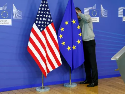 FILE PHOTO: A worker adjusts European Union and U.S. flags at the EU Commission headquarters in Brussels, November 11, 2013./File Photo