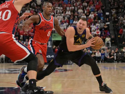 Jan 22, 2026; Inglewood, California, USA; Los Angeles Lakers guard Luka Doncic (77) is defended by Los Angeles Clippers center Ivica Zubac (40) and guard Kris Dunn (8) in the second half at Intuit Dome. Mandatory Credit: Jayne Kamin-Oncea-Imagn Images