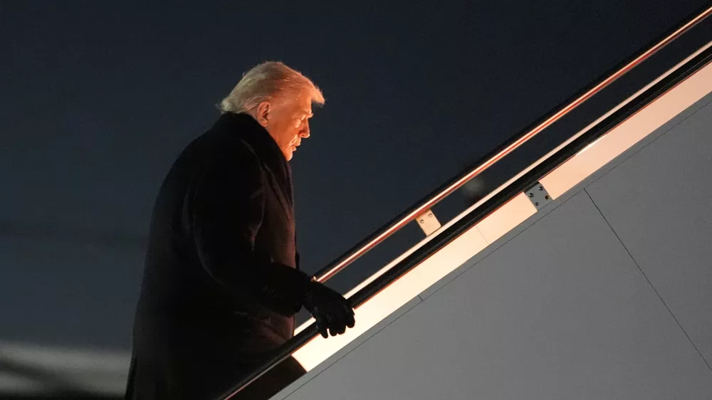 President Donald Trump boards Air Force One for a trip to attend the World Economic Form in Davos, Tuesday, Jan. 20, 2026, at Joint Base Andrews, Md. (AP Photo/Evan Vucci)