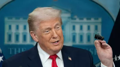 President Donald Trump holds a binder clip as he speaks during a press briefing at the White House in Washington, Tuesday, Jan. 20, 2026. (AP Photo/Mark Schiefelbein)