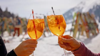 Happy family, enjoying ski holiday with children, sunny beautiful weather outdoors, people drinking Spritz on a sunny day