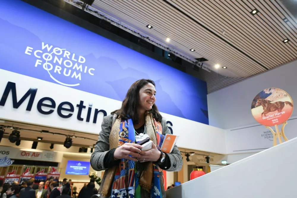 DAVOS, Jan. 21, 2026 -- A participant looks at a decoration themed on the Chinese lunar Year of the Horse during the "Dalian Night" reception at the World Economic Forum (WEF) Annual Meeting 2026 in Davos, Switzerland, Jan. 20, 2026. Northeast China's coastal city of Dalian held a reception here on Tuesday evening, featuring music performances and local gourmet cuisine. Dalian will host the WEF's Annual Meeting of the New Champions 2026, also known as the Summer Davos, in June.,Image: 1067832326, License: Rights-managed, Restrictions:, Model Release: no