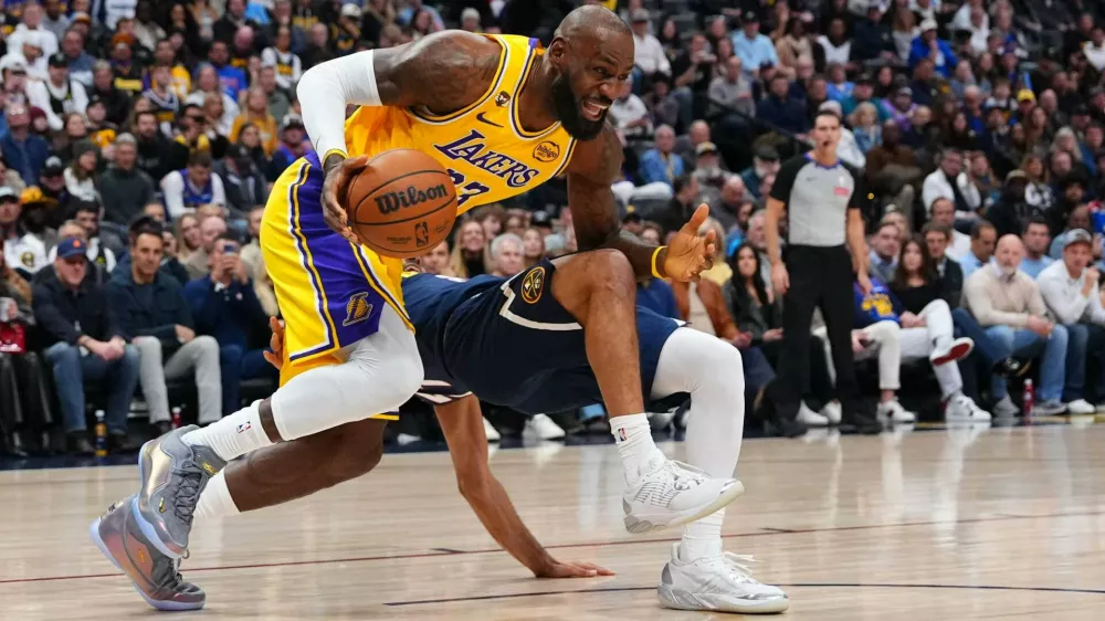 Los Angeles Lakers forward LeBron James (23) fouls Denver Nuggets guard Jamal Murray (27) during the first half of an NBA basketball game Tuesday, Jan. 20, 2026, in Denver. (AP Photo/Jack Dempsey)