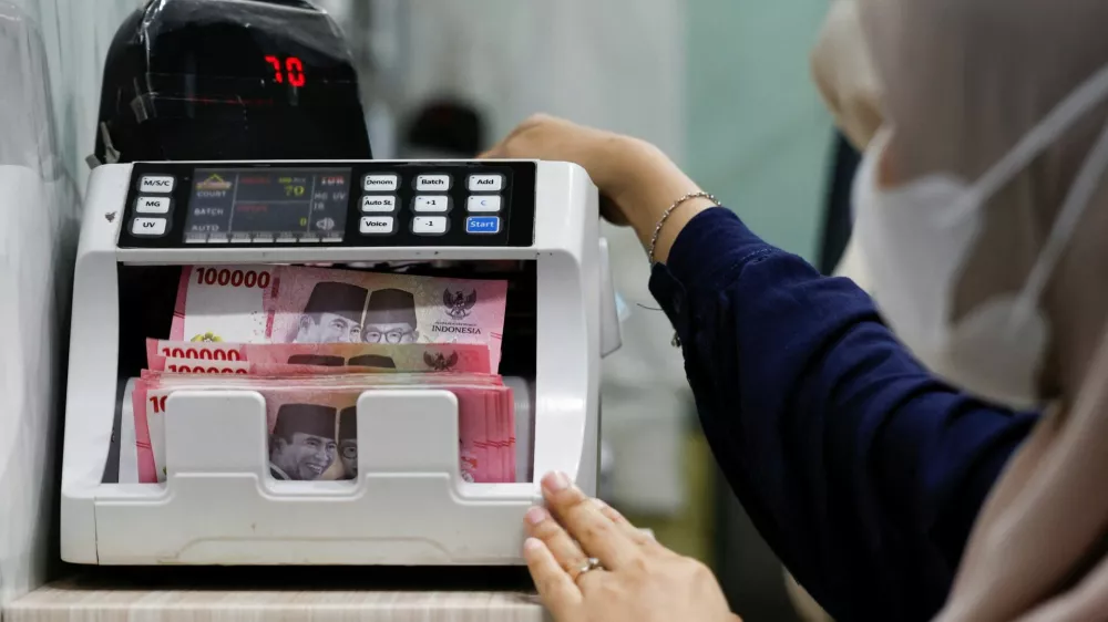 A teller counts rupiah bank notes at a money changer in Jakarta, Indonesia, January 20, 2026. REUTERS/Ajeng Dinar Ulfiana