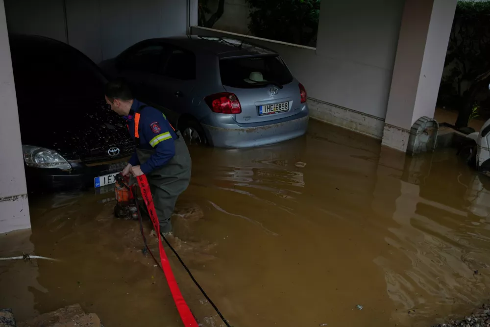 A firefighter pumps floodwater from a parking garage after flooding caused by heavy rain in the Glyfada district of Athens, Thursday, Jan. 22, 2026. (AP Photo/Thanassis Stavrakis)