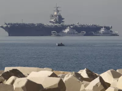 FILE - In this Thursday, March 29, 2012 file photo, a small boat pass in front of the aircraft carrier USS Enterprise is seen anchored of the coast of Faliro, near Athens. The U.S. Navy said Monday, April 9, 2012 that it has deployed a second aircraft carrier to the Persian Gulf region amid rising tensions with Iran over its nuclear program. The deployment of the nuclear-powered USS Enterprise along the Abraham Lincoln carrier strike group marks only the fourth time in the past decade that the Navy has had two aircraft carriers operating at the same time in the Persian Gulf and the Arabian Sea, said Cmdr. Amy Derrick-Frost of the Bahrain-based 5th Fleet. (AP Photo/Petros Giannakouris, File)