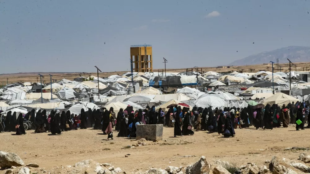 People walk at the Kurdish-run al-Hol camp, which holds relatives of suspected Islamic State (IS) group fighters in the northeastern Hasakeh governorate, on April 18, 2025, as the Syrian Democratic Forces mount a security campaign against IS "sleeper cells" in the camp. Kurdish-run camps and prisons in northeastern Syria still hold about 56,000 people from dozens of countries, many of them the family members of Islamic State group (IS) suspects, more than five years after the jihadists' territorial defeat in Syria.,Image: 989615053, License: Rights-managed, Restrictions:, Model Release: no