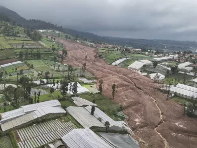 In this photo released by the Indonesian National Search and Rescue Agency (BASARNAS), an aerial shot taken using a drone shows an area affected by landslides in Pasir Langu village, in West Bandung district of West Java province, Indonesia, Saturday, Jan. 24, 2026. (BASARNAS via AP)