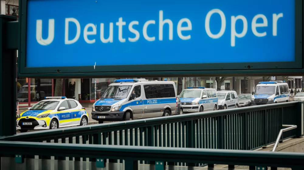 24 January 2026, Berlin: Police vehicles are parked near the entrance to the Deutsche Oper subway station. A teenager suffered a fatal electric shock in a Berlin subway station when he tried to retrieve his fallen e-cigarette from the track bed. Photo: Christoph Soeder/dpa