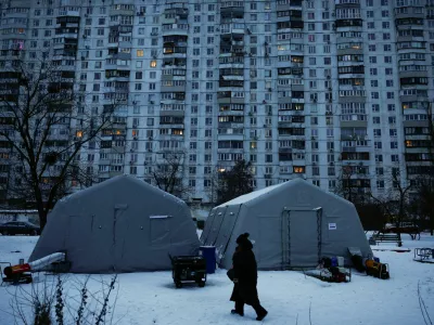A person walks past a Point of Invincibility centre, a government‑run shelter that provides basic services and heat during blackouts, set up next to an apartment building left without heating and facing long power cuts after critical civil infrastructure was hit by recent Russian missile and drone strikes, amid Russia's attack on Ukraine, in Kyiv, Ukraine, January 23, 2026. REUTERS/Alina Smutko