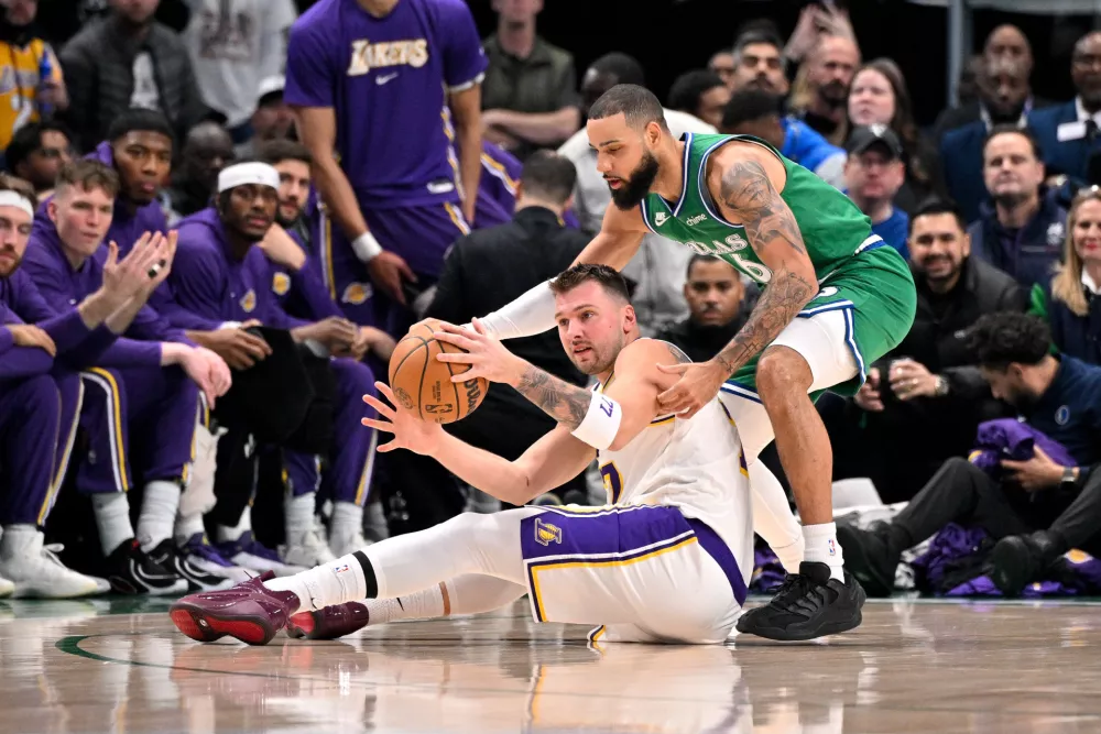 Jan 24, 2026; Dallas, Texas, USA; Los Angeles Lakers guard Luka Doncic (77) and Dallas Mavericks forward Caleb Martin (16) battle for control of the loose ball during the first quarter at the American Airlines Center. Mandatory Credit: Jerome Miron-Imagn Images