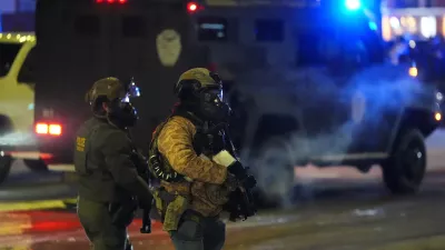 Federal agents stand guard as they try to clear the demonstrators near a hotel, using tear gas during a noise demonstration protest in response to federal immigration enforcement operations in the city Sunday, Jan. 25, 2026, in Minneapolis. (AP Photo/Adam Gray)