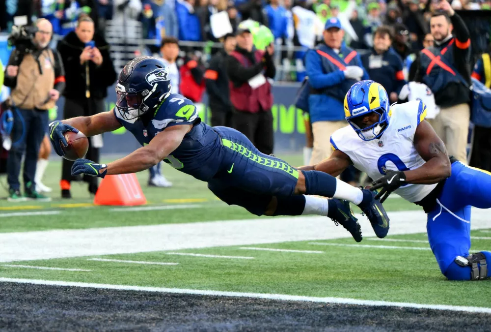Jan 25, 2026; Seattle, WA, USA; Seattle Seahawks running back Kenneth Walker III (9) reaches for a touchdown against Los Angeles Rams linebacker Byron Young (0) in the first half in the 2026 NFC Championship Game at Lumen Field. Mandatory Credit: Steven Bisig-Imagn Images   TPX IMAGES OF THE DAY