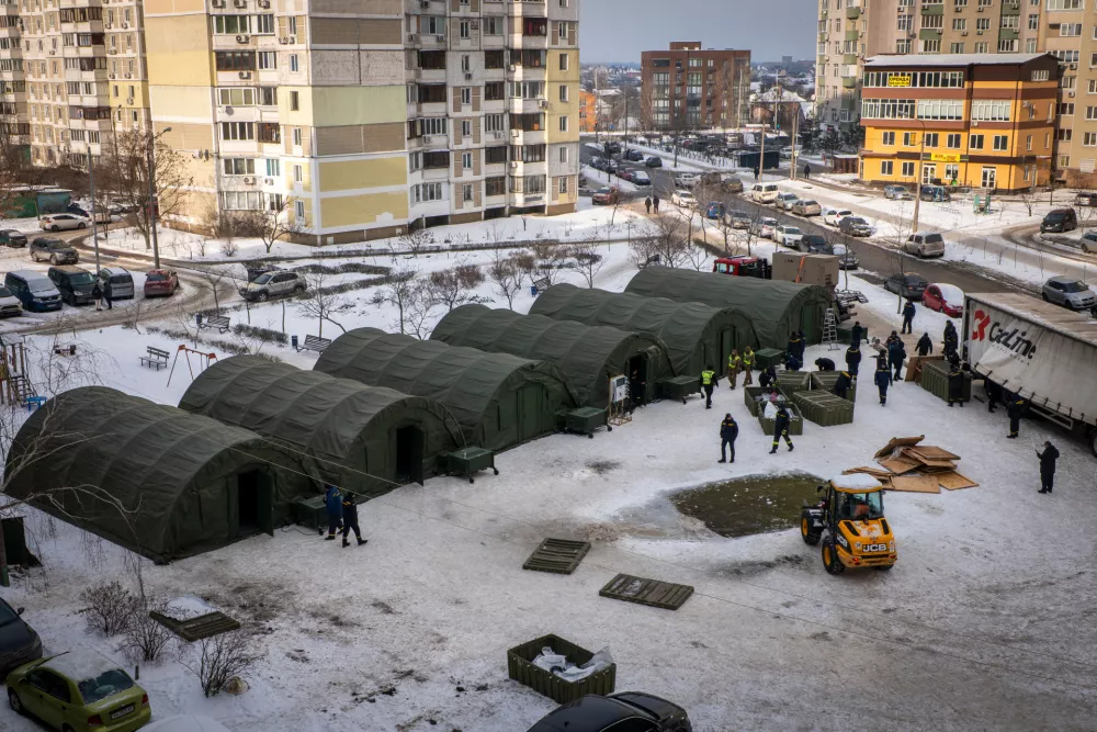 Emergency service workers set up tents where residents of neighbouring apartment buildings can warm up and sleep at night in Kyiv, Ukraine, Sunday, Jan. 25, 2026. (AP Photo/Dan Bashakov)