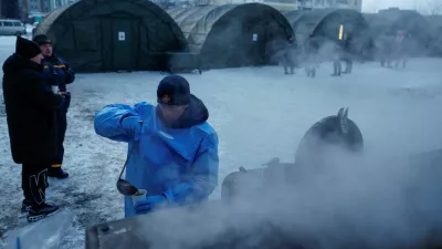 FILE PHOTO: A State Emergency Service employee pours tea into a cup in front of tents of a government-run humanitarian aid point, where residents can warm up, charge their devices, get hot drinks and psychological support, installed next to apartment buildings during a power blackout after critical civil infrastructure was hit by recent Russian missile and drone strikes, amid Russia's attack on Ukraine, in Kyiv, Ukraine, January 25, 2026. REUTERS/Valentyn Ogirenko/File Photo